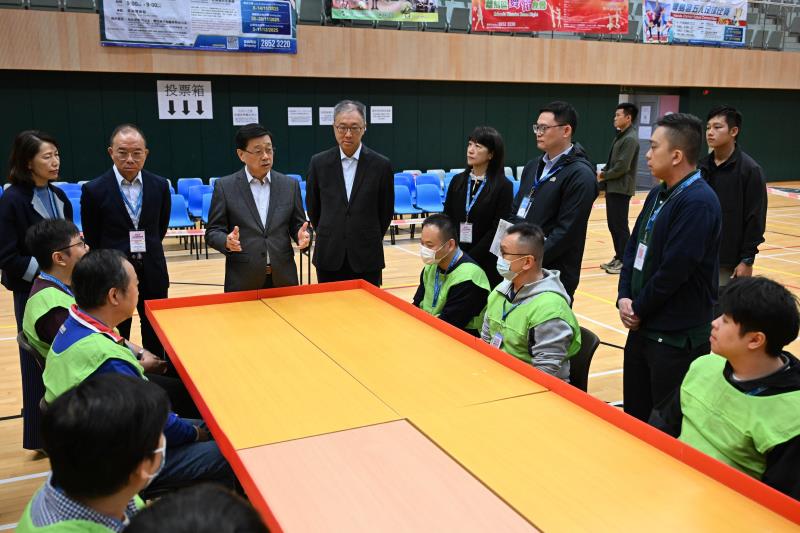 行政長官李家超(左三)在官員陪同下視察設於東涌文東路體育館投票站