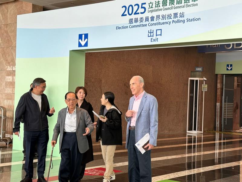 地產建設商會執委會主席梁志堅 (左二)到會展票站投票。(梁雪瑩攝)