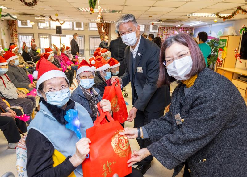 謝小華（右一）和鄭祖瀛（右二）派發環保福袋給東華三院方樹泉社會服務大 樓內護老院的長者們，為他們在節日前加添暖意。